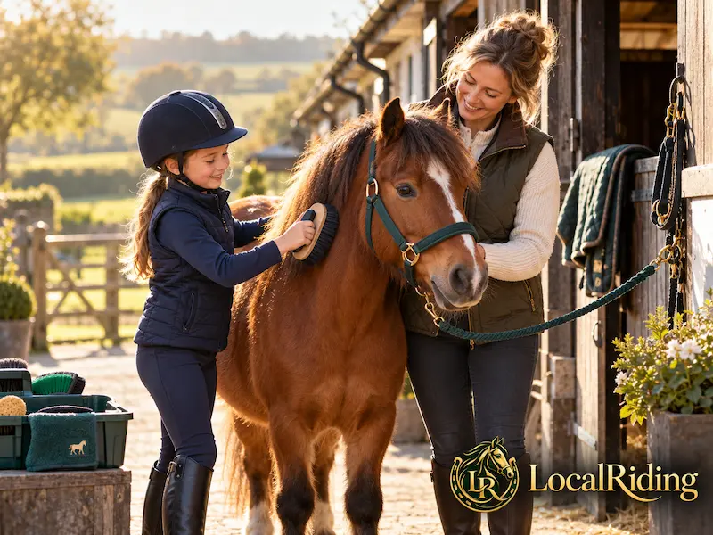 A child grooms her first pony at the yard with her mother
